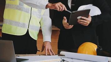 arquitecto hombre trabajando con ordenador portátil y planos, ingeniero inspección en lugar de trabajo para arquitectónico plan, bosquejo un construcción proyecto ,selectivo foco,negocio concepto Clásico color video