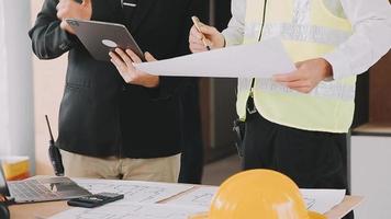 arquitecto hombre trabajando con ordenador portátil y planos, ingeniero inspección en lugar de trabajo para arquitectónico plan, bosquejo un construcción proyecto ,selectivo foco,negocio concepto Clásico color video