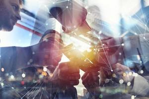 Business people join puzzle pieces in office. Concept of teamwork and partnership. double exposure with internet network effects photo