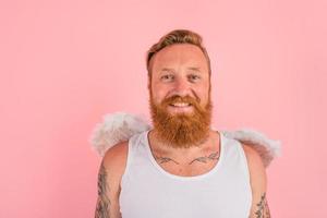 Happy man with beard and tattoos acts like an angel photo