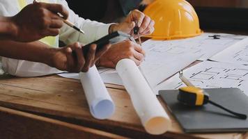 arquiteto homem trabalhando com computador portátil e plantas, engenheiro inspeção dentro local de trabalho para arquitetônico planejar, esboçar uma construção projeto ,seletivo foco, negócios conceito vintage cor video