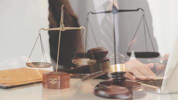 Justice and law concept.Male judge in a courtroom with the gavel, working with, computer and docking keyboard, eyeglasses, on table in morning light video