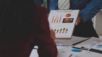 Financial analysts analyze business financial reports on a digital tablet planning investment project during a discussion at a meeting of corporate showing the results of their successful teamwork. video