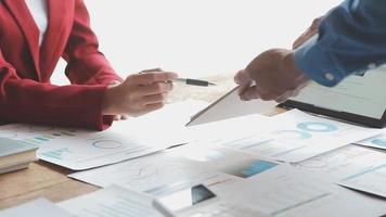 Financial analysts analyze business financial reports on a digital tablet planning investment project during a discussion at a meeting of corporate showing the results of their successful teamwork. video