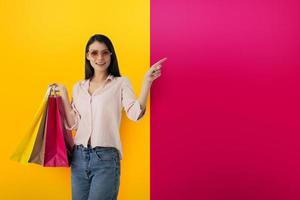 Happy woman with shopping bags in hand indicates something photo