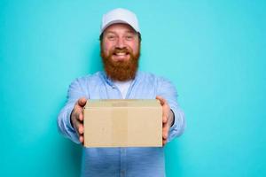 Courier with hat is happy to deliver a carton box photo