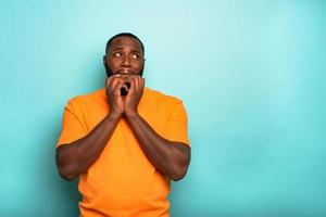 Man is afraid about something over a cyan background photo