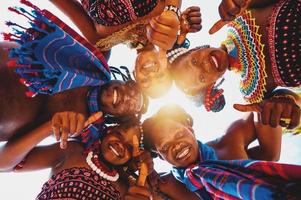 Local people with typical kenyan clothes hug and smile together photo