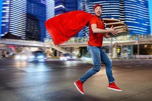 Deliveryman with pizzas acts like a powerful superhero. Concept of success and guarantee on shipment. photo