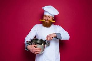 Happy chef with beard and red apron is ready to cook photo