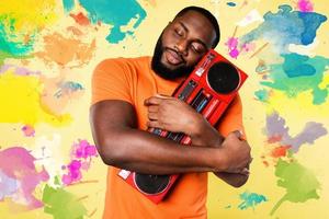 Man hugs an old stereo. he love the music. yellow background photo