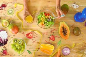 mujer prepara un sano comida con ensalada y naranja jugo foto