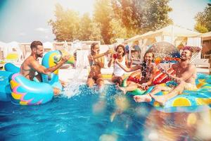 Group of friends in swimsuit enjoy in a swimming pool photo