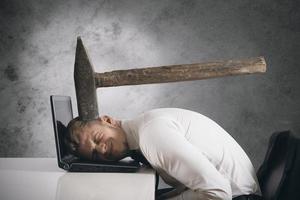 Concept of stress with businessman with an big hammer over head photo