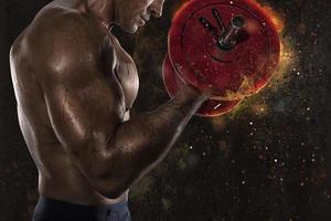 Athletic man training biceps at the gym with fire effect photo