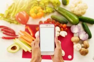 cocinar sigue un receta de vegetales desde el teléfono inteligente foto
