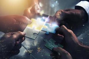 Businessmen working together to build a puzzle. Concept of teamwork, partnership, integration and startup. photo
