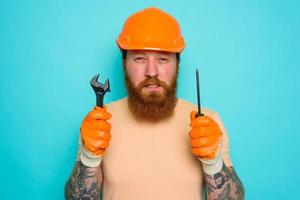 trabajador con amarillo sombrero es confuso acerca de su trabajo foto