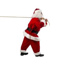 Santa claus pulls a rope to move something photo