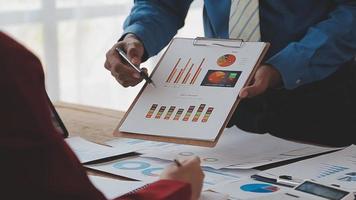 Financial analysts analyze business financial reports on a digital tablet planning investment project during a discussion at a meeting of corporate showing the results of their successful teamwork. video