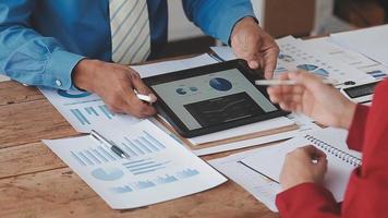 Financial analysts analyze business financial reports on a digital tablet planning investment project during a discussion at a meeting of corporate showing the results of their successful teamwork. video