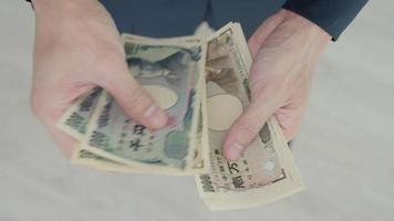Japonais yen argent. proche en haut de le Japonais yen sur main. devise de Japon cette est utilisé à changement, acheter, vendre, accumuler, investir, financier, échange taux, valeur, comptabilité, international échange video