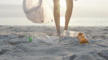 opslaan water. vrijwilliger plukken omhoog uitschot vuilnis Bij de strand en plastic flessen zijn moeilijk ontleden voorkomen kwaad aquatisch leven. aarde, omgeving, vergroening planeet, verminderen globaal opwarming, opslaan wereld video