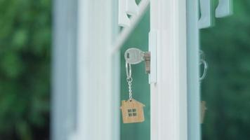 Vermieterschlüssel zum Aufschließen des Hauses steckt in der Tür. Haus aus zweiter Hand zu vermieten und zu verkaufen. Schlüsselbund weht im Wind. hypothek für neues zuhause, kaufen, verkaufen, renovieren, investition, eigentümer, nachlass video