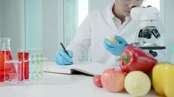 cientista verifica resíduos químicos de frutas em laboratório. especialistas em controle inspecionam a concentração de resíduos químicos. perigos, padrão, encontrar substâncias proibidas, contaminar, microbiologista video