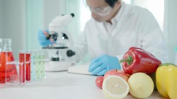 el científico comprueba los residuos de frutas químicas en el laboratorio. los expertos en control inspeccionan la concentración de residuos químicos. peligros, estándar, encontrar sustancias prohibidas, contaminar, microbiólogo video