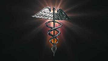 The Caduceus medical symbol rotating on a golden lens flare - Loop video
