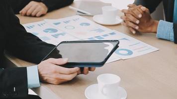 Financial analysts analyze business financial reports on a digital tablet planning investment project during a discussion at a meeting of corporate showing the results of their successful teamwork. video