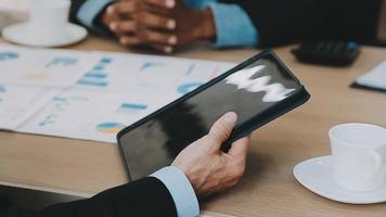 Financial analysts analyze business financial reports on a digital tablet planning investment project during a discussion at a meeting of corporate showing the results of their successful teamwork. video