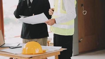 arquitecto hombre trabajando con ordenador portátil y planos, ingeniero inspección en lugar de trabajo para arquitectónico plan, bosquejo un construcción proyecto ,selectivo foco,negocio concepto Clásico color video