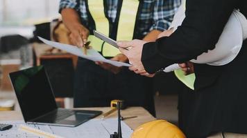 arquitecto hombre trabajando con ordenador portátil y planos, ingeniero inspección en lugar de trabajo para arquitectónico plan, bosquejo un construcción proyecto ,selectivo foco,negocio concepto Clásico color video