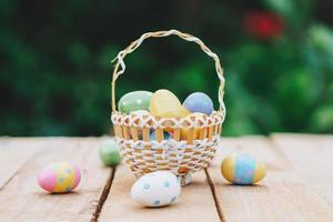 Colorful easter eggs in basket on wooden table win copy space. photo