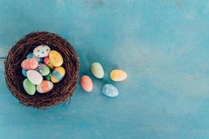 vistoso Pascua de Resurrección huevo en el nido en azul pastel color madera antecedentes con espacio. foto