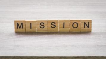 Wooden block with mission massage on wood table background. photo