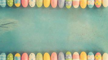 Colorful easter eggs on wooden pastel color background with space. photo