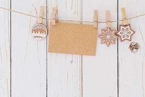 Close up of christmas decoration and blank paper card hanging on wood background. photo