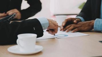 Financial analysts analyze business financial reports on a digital tablet planning investment project during a discussion at a meeting of corporate showing the results of their successful teamwork. video