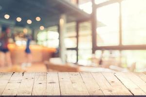 Empty wood table and Blurred background  Customer at coffee shop blur background with bokeh, Vintage toned. photo