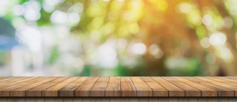 Empty wood table and defocused bokeh and blur background of garden trees with sunlight. product display template. photo