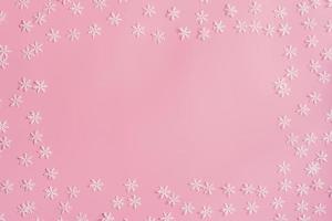 Top view Christmas snowflake border frame on pink background. Xmas minimal texture with copy space. photo