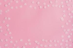 Top view Christmas snowflake border frame on pink background. Xmas minimal texture with copy space. photo