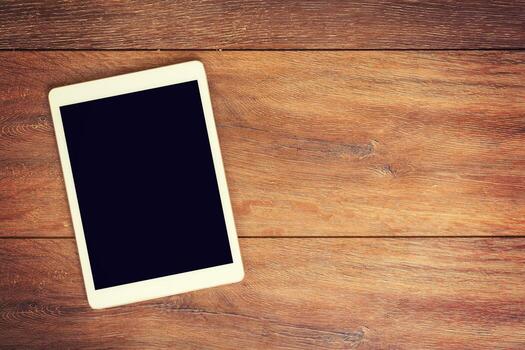 Blank Tablet computer on wood table background with space for text. photo