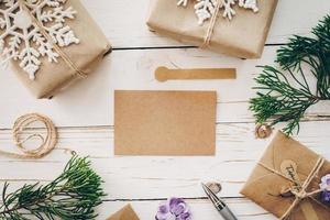 Top view of empty christmas card on wooden table with xmas decoration. photo