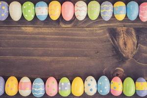 Colorful easter eggs on plank wooden background with space. photo