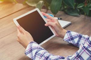 Asia woman using tablet on table in coffee shop photo