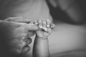 Newborn baby touching his mother hand photo